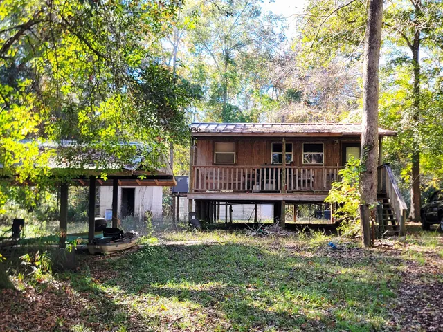 a view of a house with a yard and hanging chair