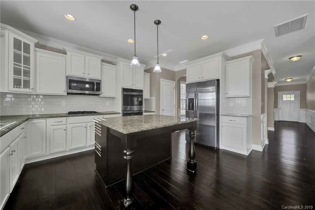 264 Annatto Way Tega Cay, SC 29708 - Photo 12 of 36 a kitchen with stainless steel appliances granite countertop a sink a stove and a refrigerator