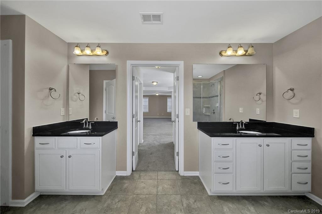 264 Annatto Way Tega Cay, SC 29708 - Photo 27 of 36 a hallway with granite countertop a sink and a wooden cabinets