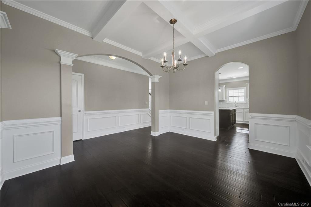 264 Annatto Way Tega Cay, SC 29708 - Photo 8 of 36 an empty room with wooden floor chandelier and windows