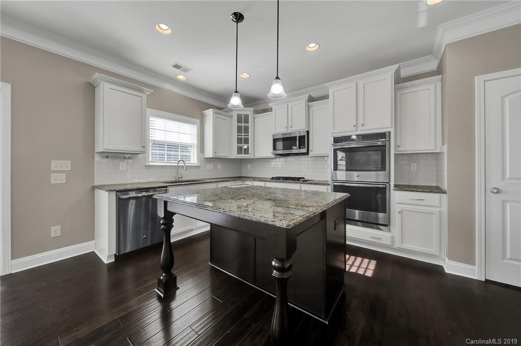 264 Annatto Way Tega Cay, SC 29708 - Photo 10 of 36 a kitchen with kitchen island granite countertop a sink appliances and wooden floor