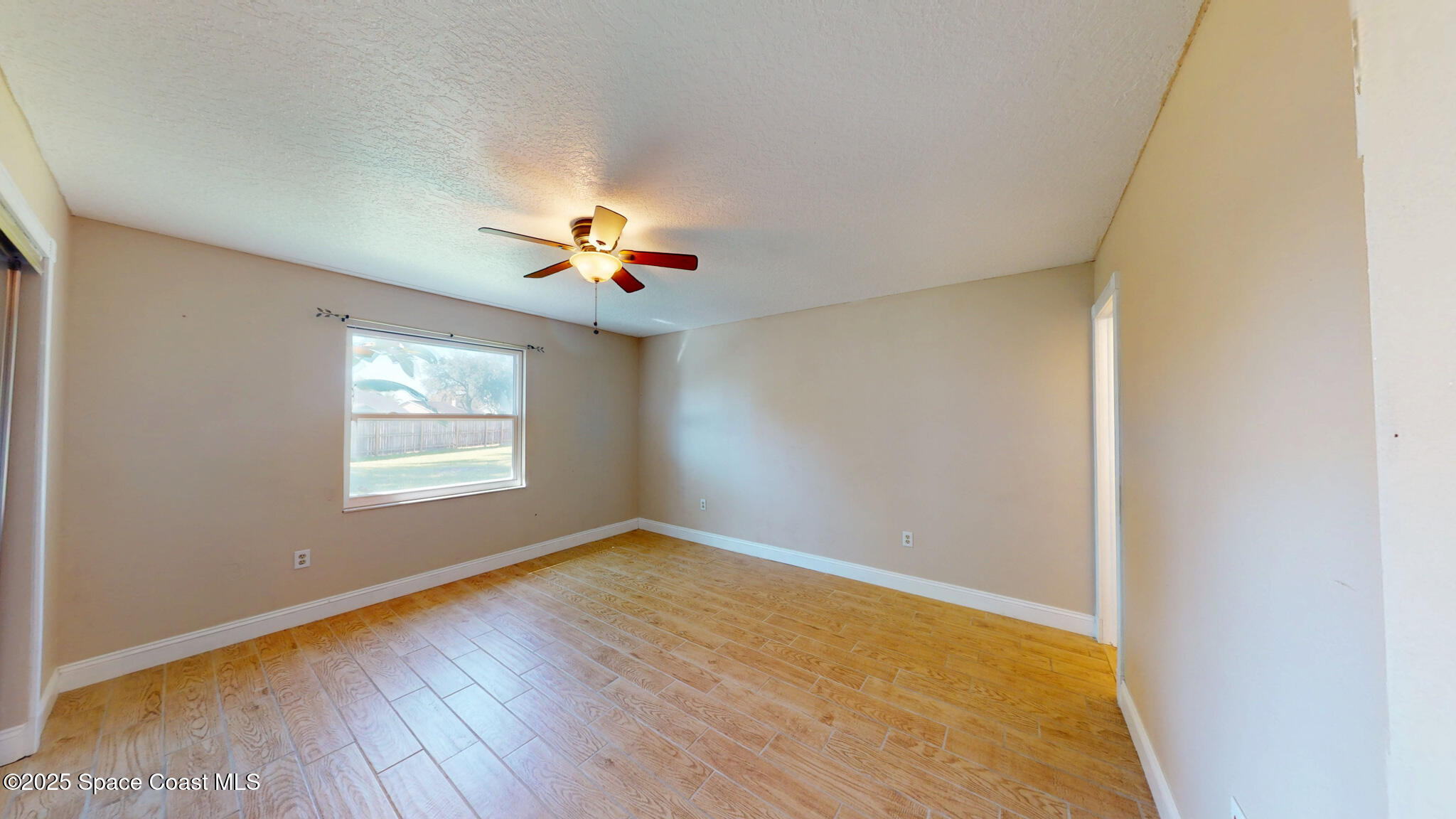 871 Southern Pine Trail Rockledge, FL 32955 - Photo 13 of 37 a view of an empty room with wooden floor and a window