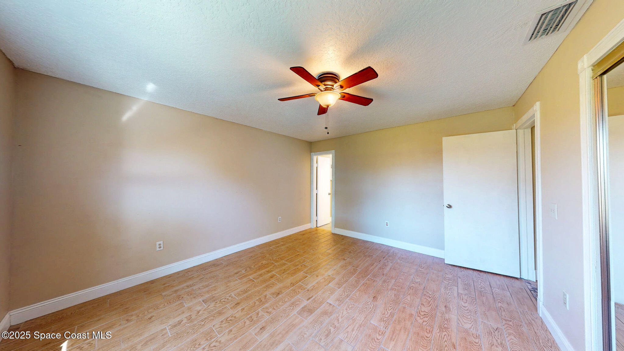 871 Southern Pine Trail Rockledge, FL 32955 - Photo 16 of 37 a view of a big room with wooden floor and a chandelier fan