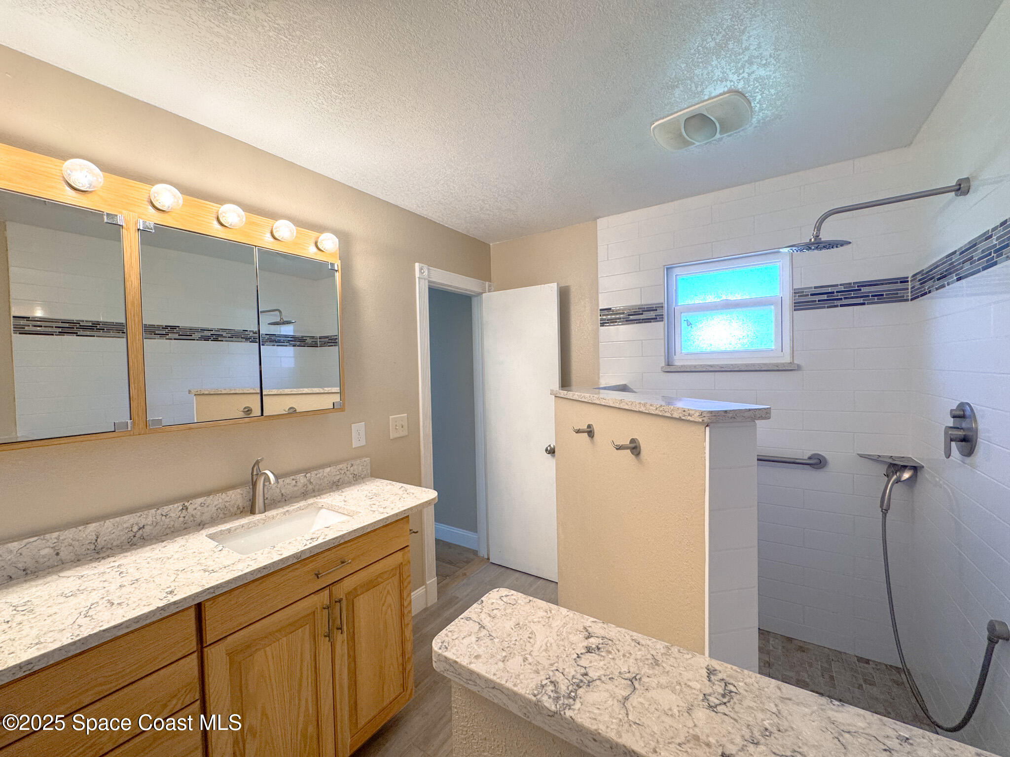 871 Southern Pine Trail Rockledge, FL 32955 - Photo 18 of 37 a bathroom with a granite countertop sink a mirror and shower