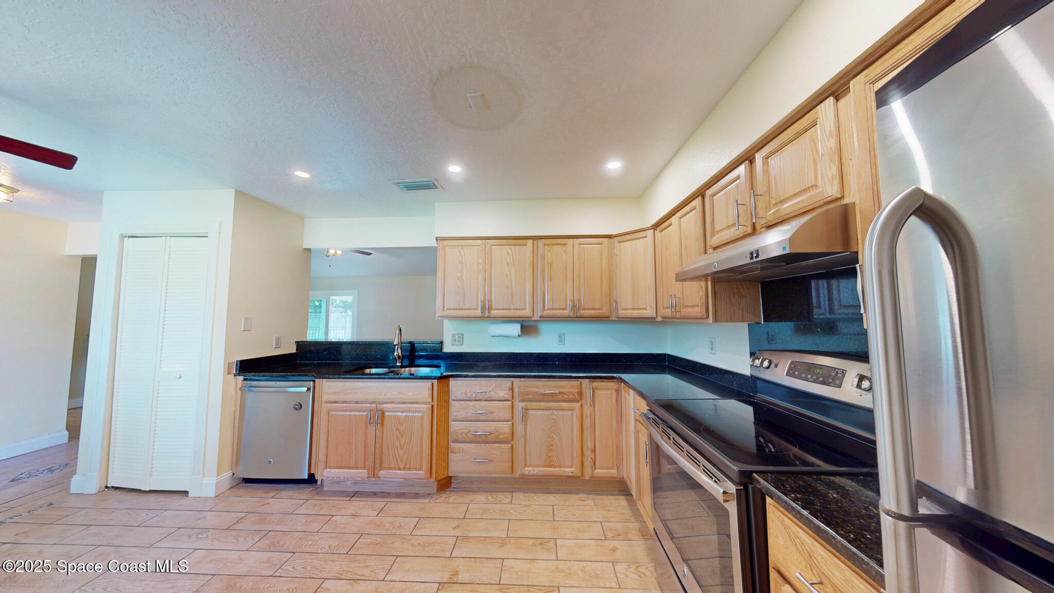 871 Southern Pine Trail Rockledge, FL 32955 - Photo 6 of 36 a kitchen with granite countertop a stove sink and cabinets