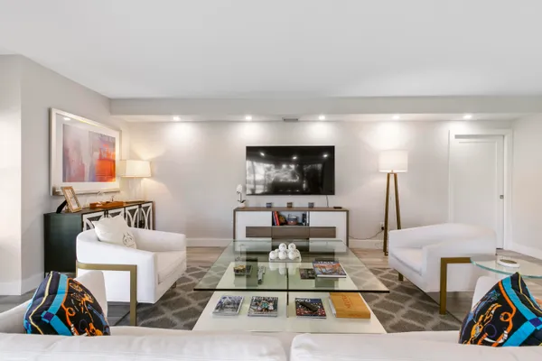 a living room with furniture a flat screen tv and a table