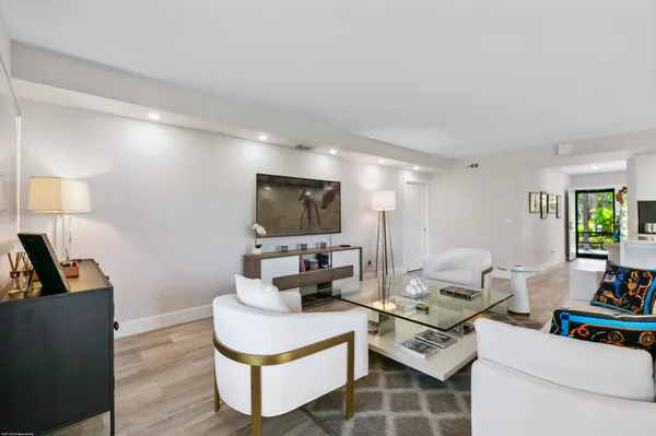 a living room with furniture a flat screen tv and a lamp