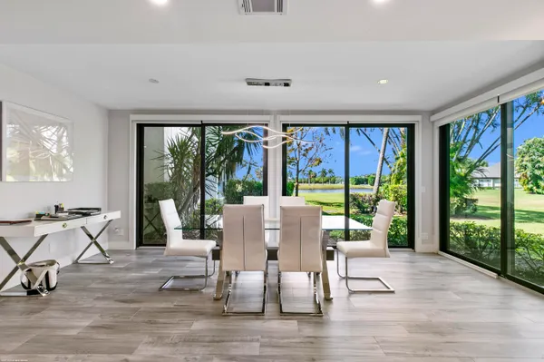a view of a dining room with furniture large windows and wooden floor