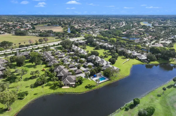 an aerial view of a houses with a yard and lake view