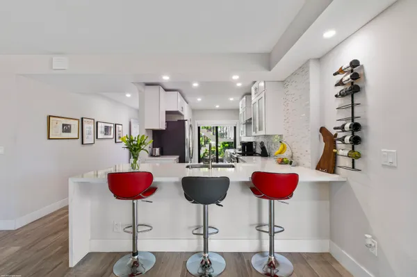 a kitchen with stainless steel appliances kitchen island granite countertop cabinets and chair