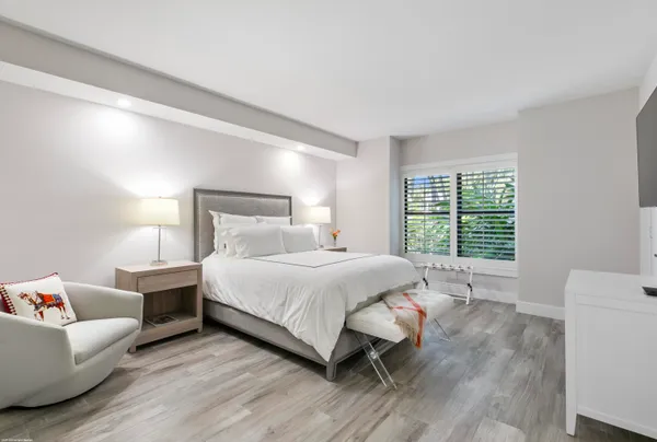 a bedroom with a bed wooden floor and window