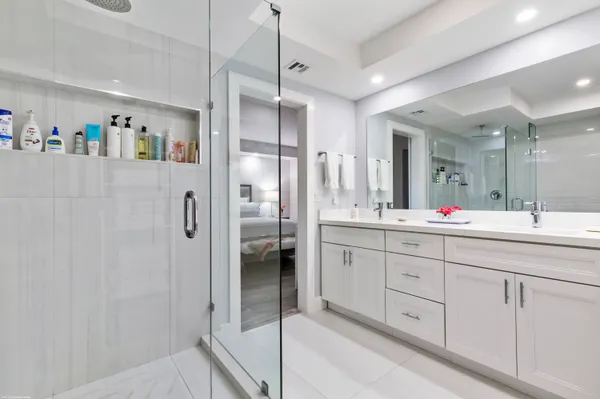 a bathroom with double vanity shower and a sink