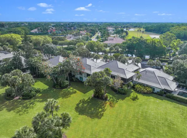 an aerial view of residential houses with outdoor space and trees