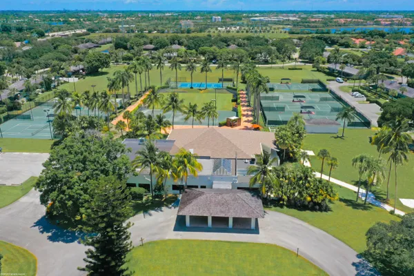 an aerial view of residential houses with outdoor space and trees