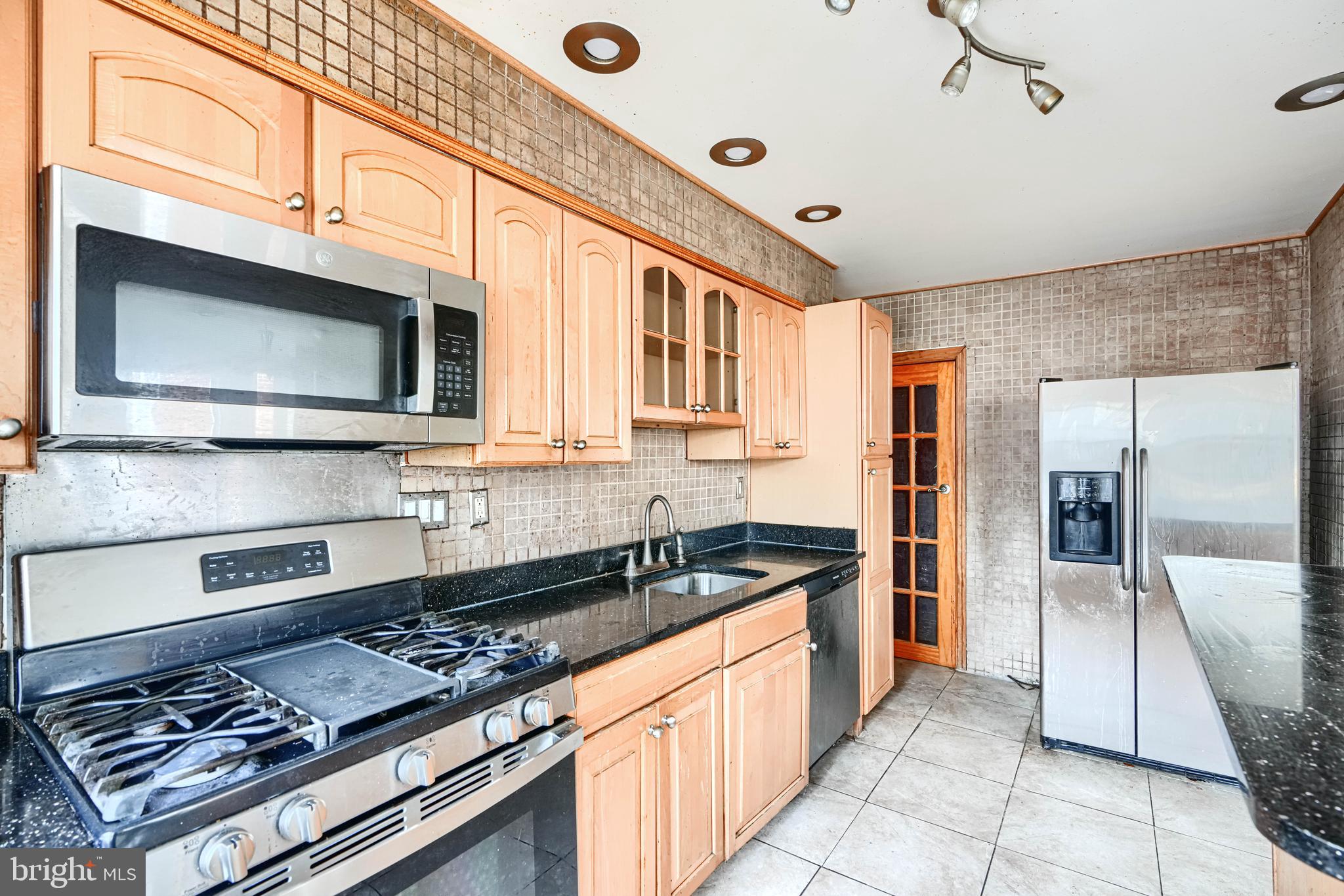 1517 Medford Road Baltimore, MD 21218 - Photo 14 of 27 a kitchen with stainless steel appliances granite countertop a stove and a microwave
