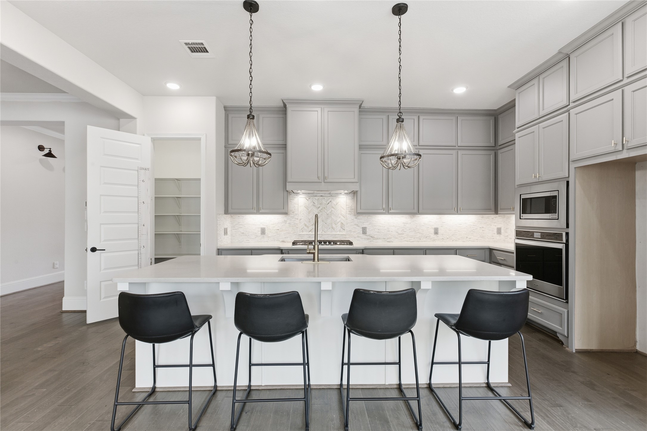 633 Ashbrook Ridge Lane Pinehurst, TX 77362 - Photo 10 of 35 a kitchen with stainless steel appliances kitchen island granite countertop a dining table chairs and white cabinets