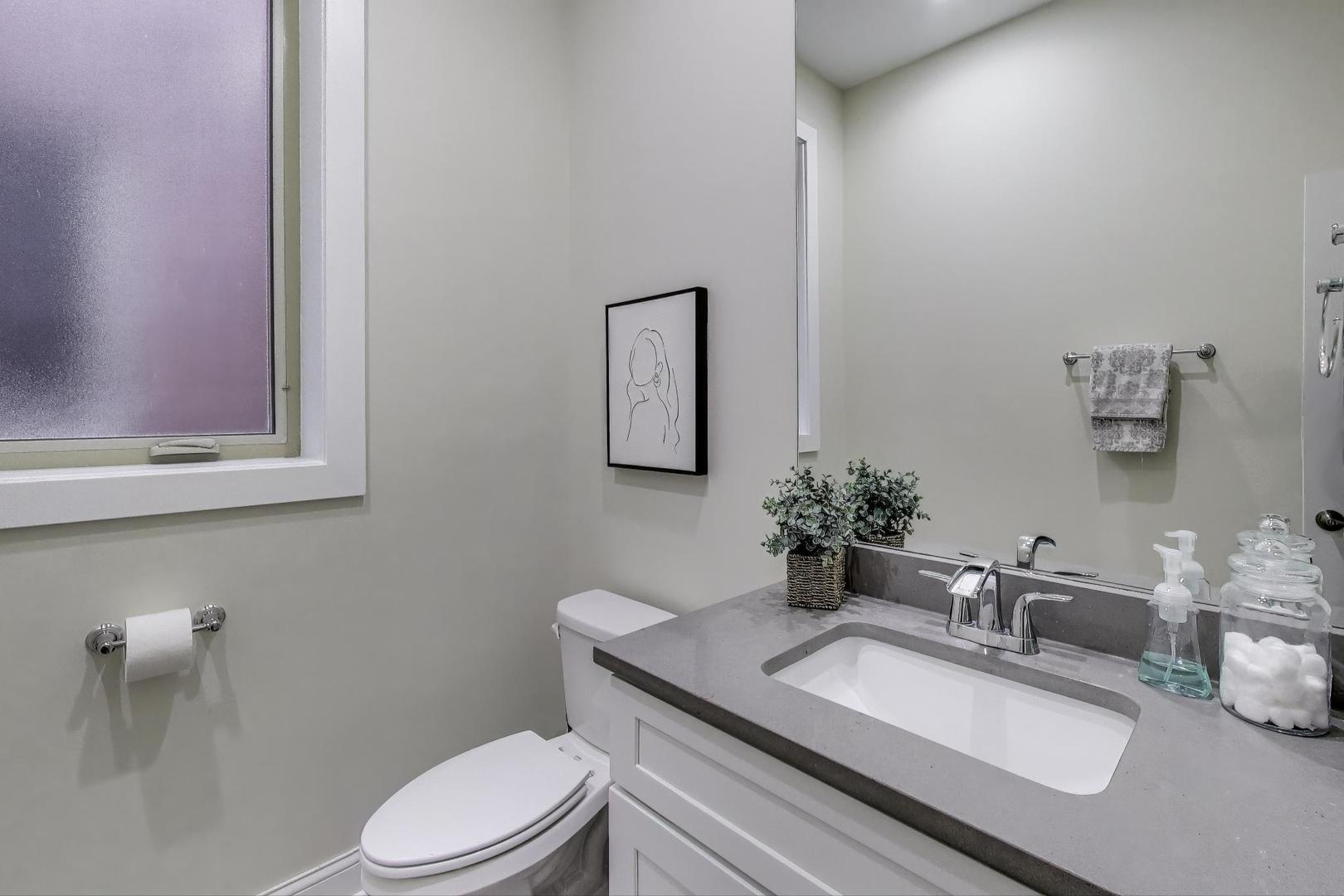 1045 West 34th Place Chicago, IL 60608 - Photo 12 of 35 a bathroom with a granite countertop sink mirror vanity and toilet