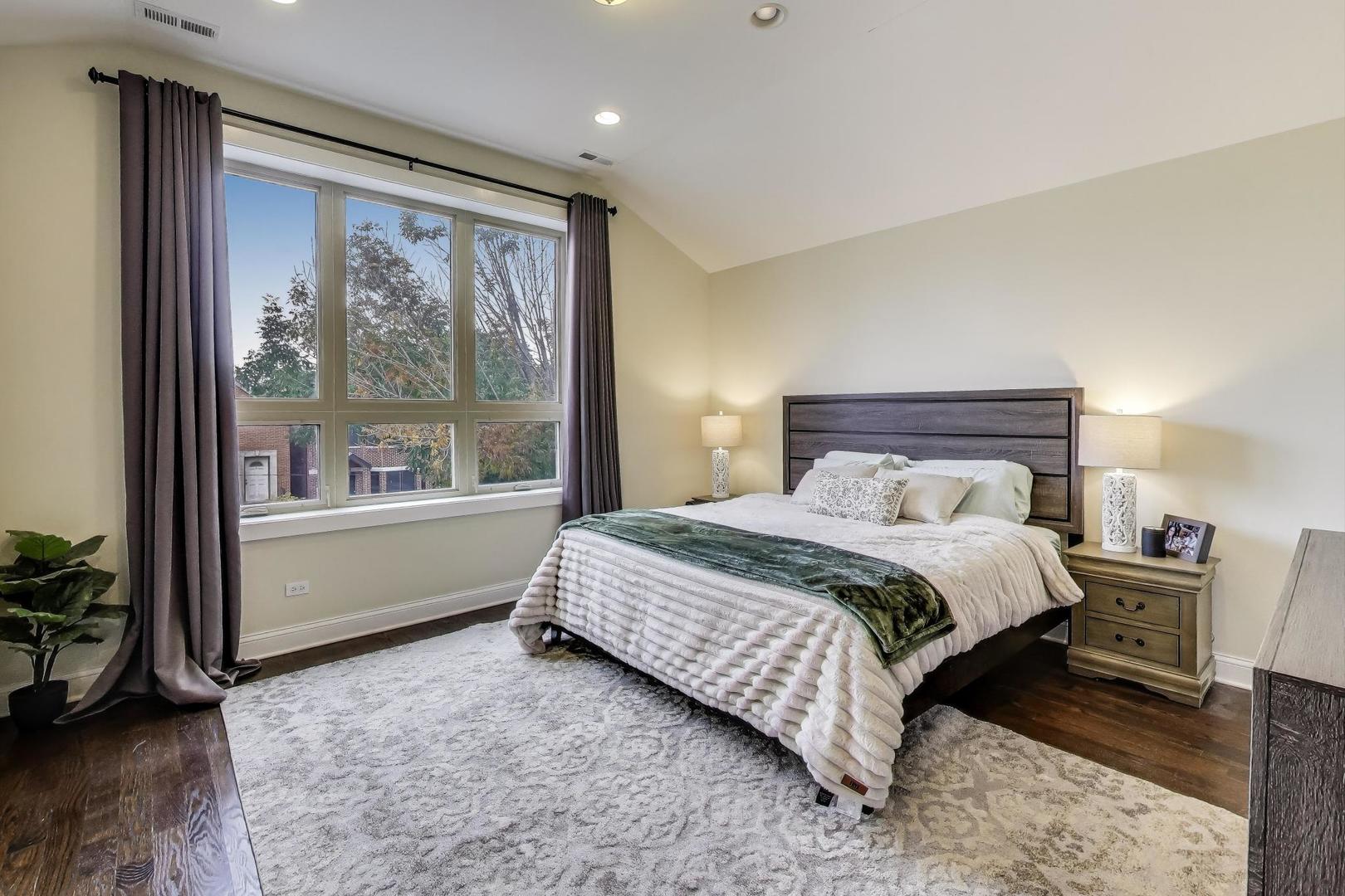 1045 West 34th Place Chicago, IL 60608 - Photo 13 of 35 a bedroom with a large bed and a large window