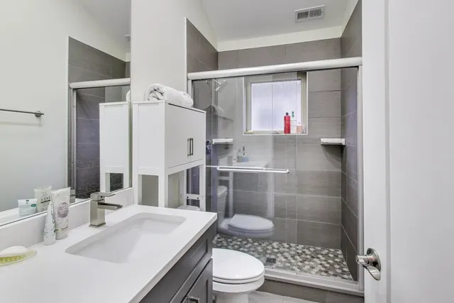 a bathroom with a sink toilet a mirror and shower