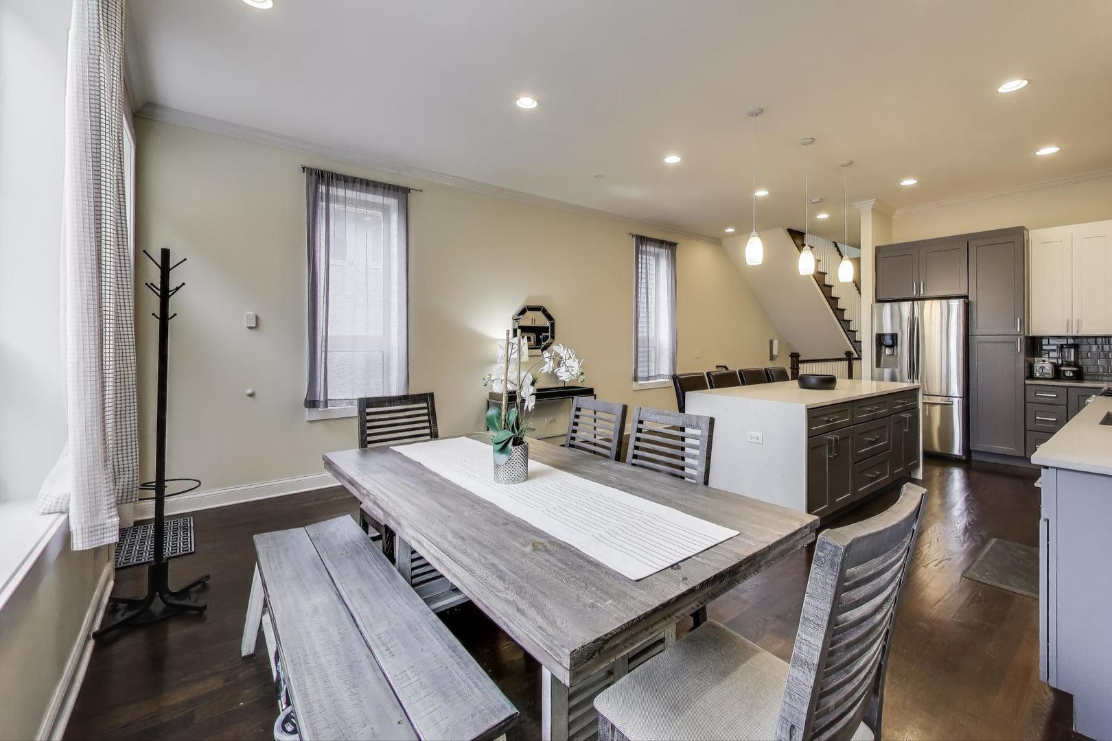 1045 West 34th Place Chicago, IL 60608 - Photo 7 of 35 a kitchen with a table chairs refrigerator and microwave