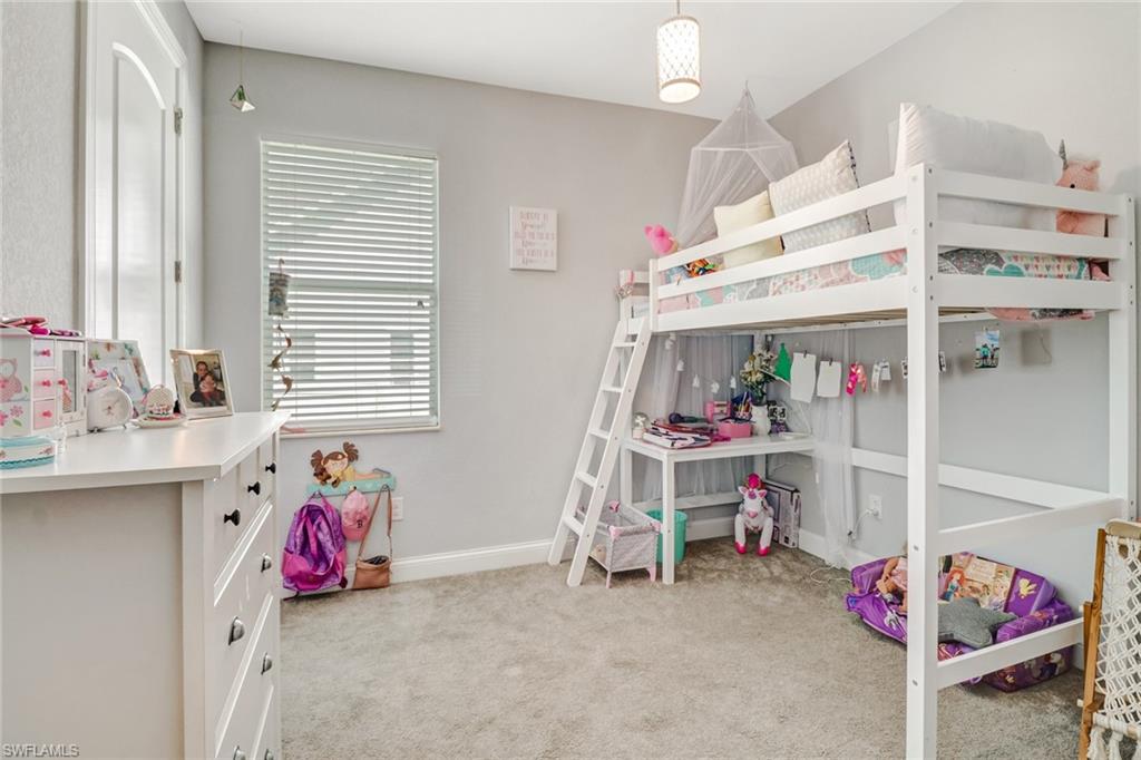 8476 Grove Road Fort Myers, FL 33967 - Photo 18 of 25 a bedroom with a bed and a chandelier