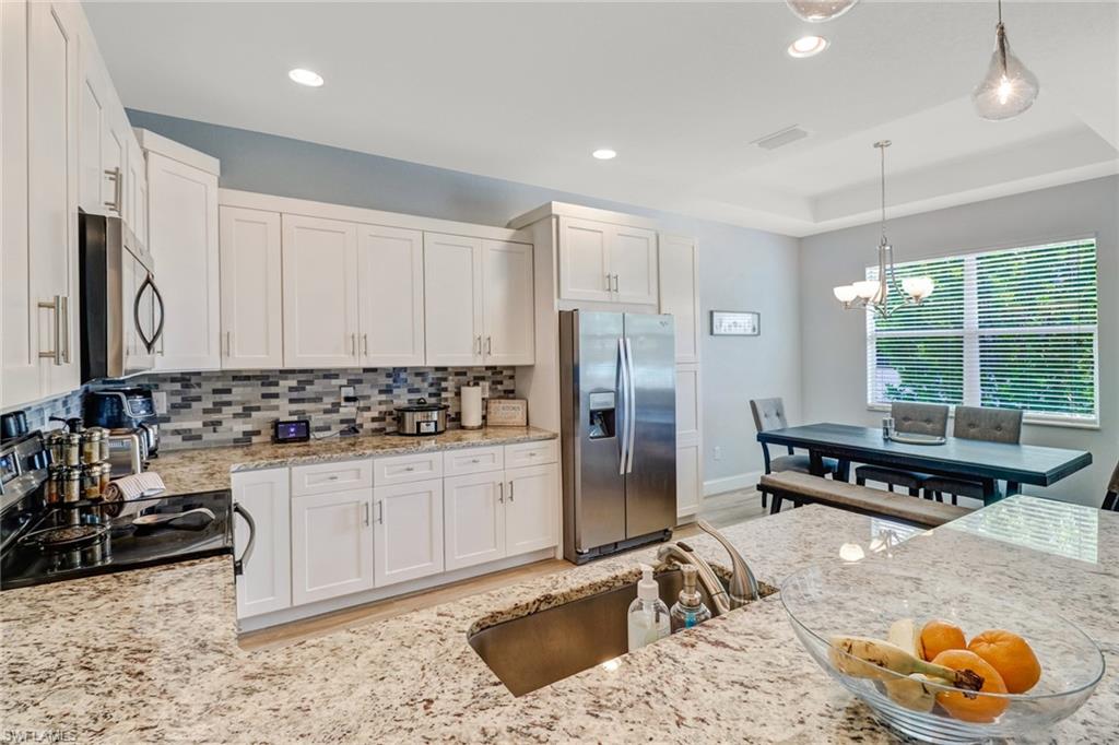 8476 Grove Road Fort Myers, FL 33967 - Photo 5 of 25 a kitchen with stainless steel appliances granite countertop a sink and a refrigerator