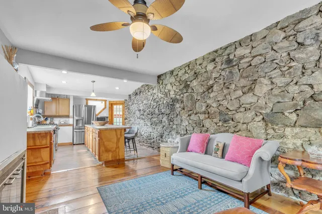 a living room with stainless steel appliances furniture and a rug