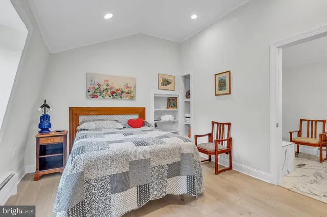 a bedroom with a bed and painting on the wall