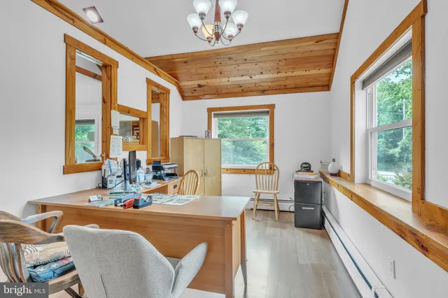 a dining room with furniture a chandelier and large windows