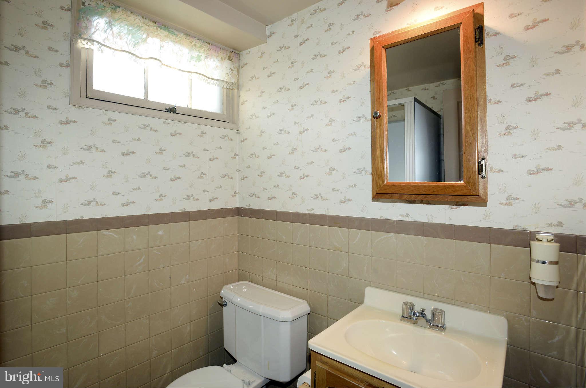 3913 Isbell Street Silver Spring, MD 20906 - Photo 20 of 23 a bathroom with a toilet sink and mirror