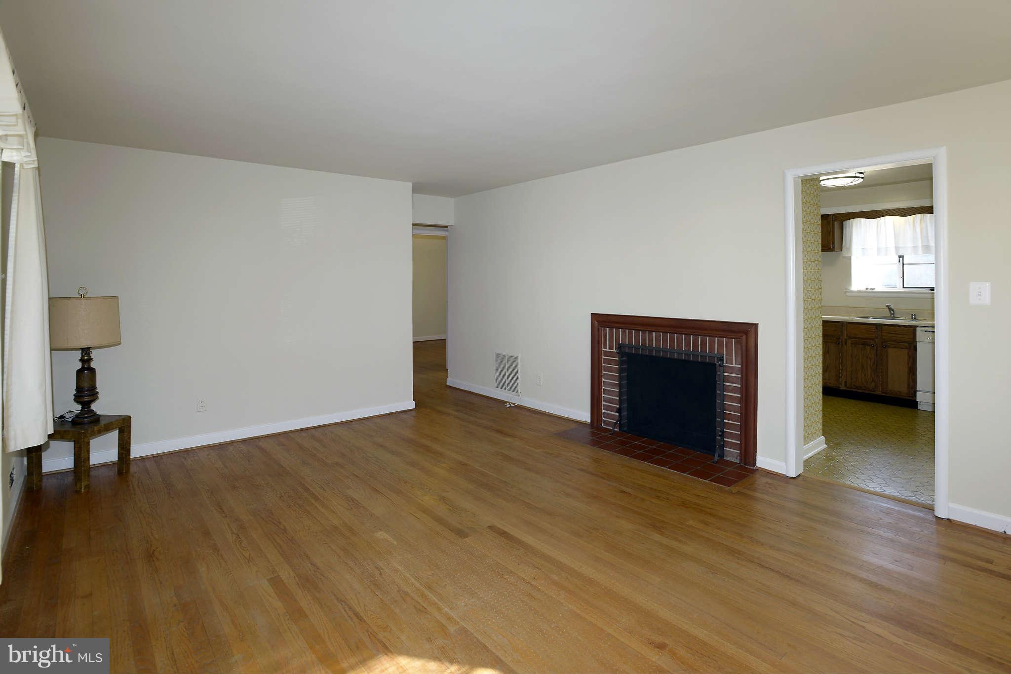 3913 Isbell Street Silver Spring, MD 20906 - Photo 3 of 23 a view of empty room with wooden floor and fireplace