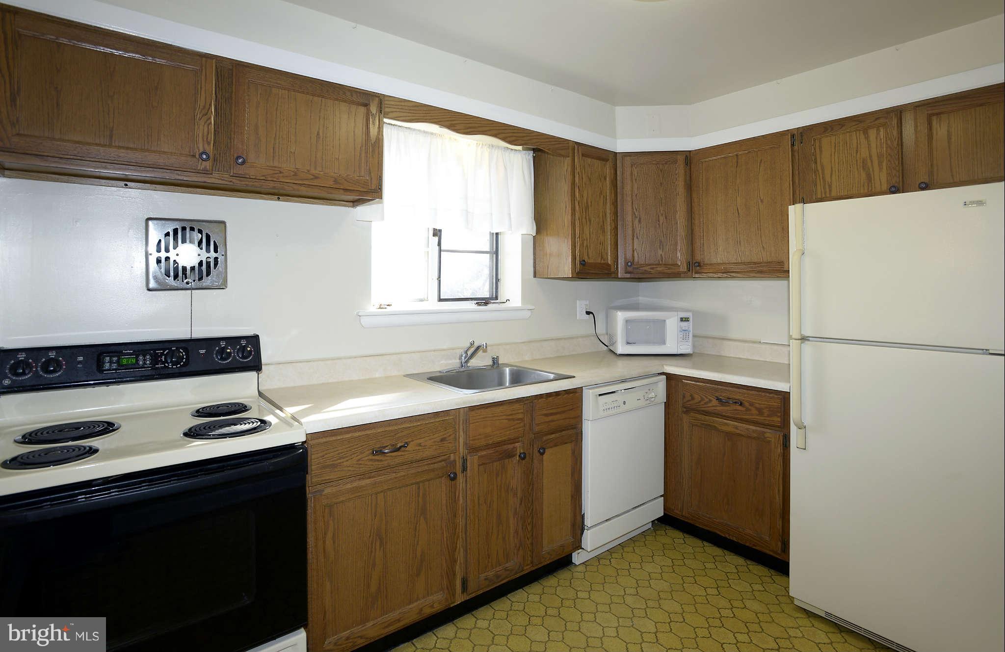 3913 Isbell Street Silver Spring, MD 20906 - Photo 7 of 23 a kitchen with a refrigerator sink and cabinets
