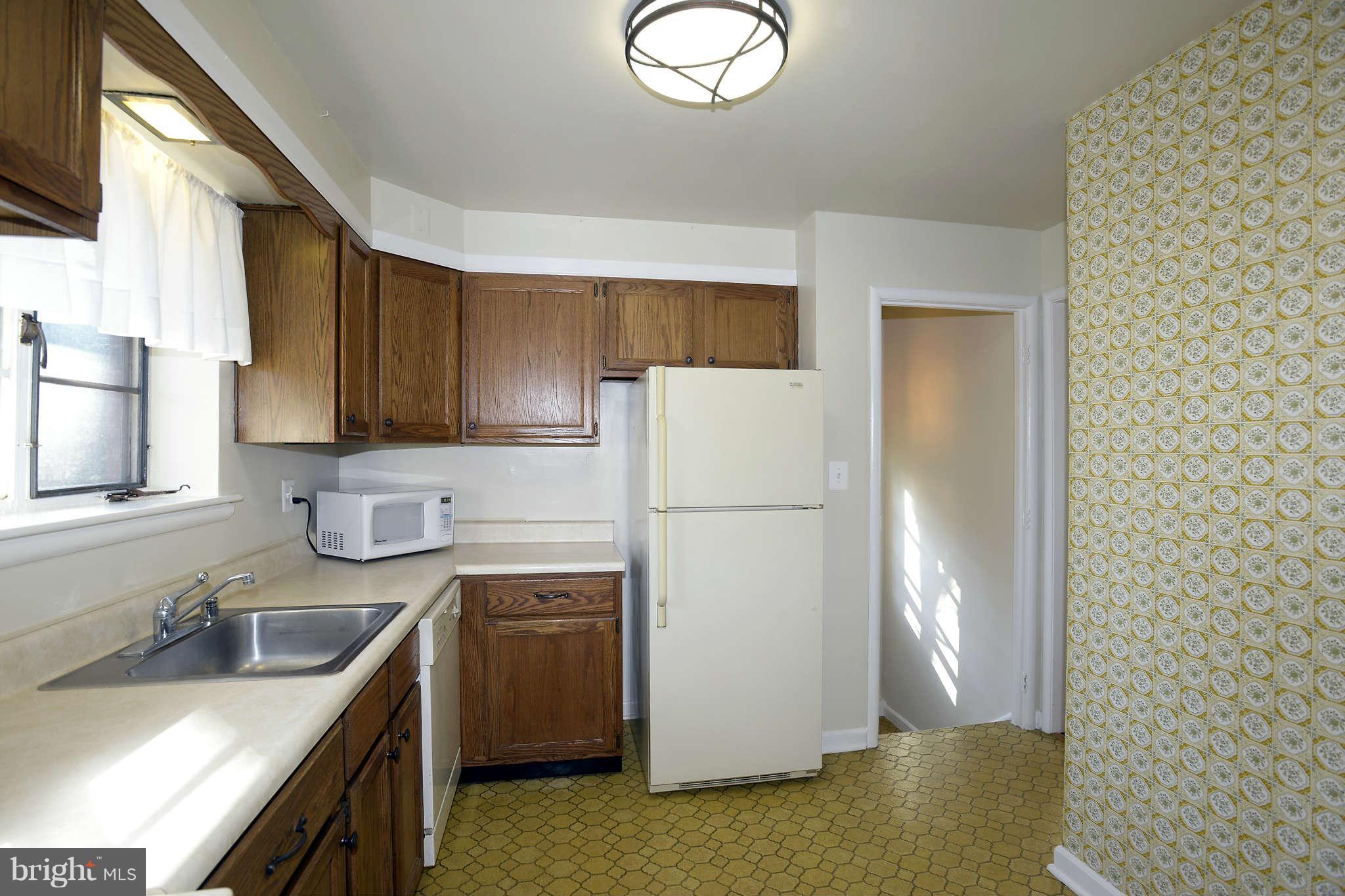 3913 Isbell Street Silver Spring, MD 20906 - Photo 8 of 23 a kitchen with a sink a stove a refrigerator and cabinets