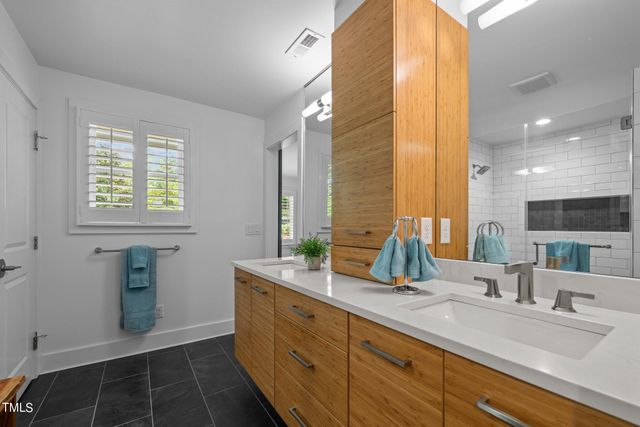 a bathroom with double vanity and a mirror