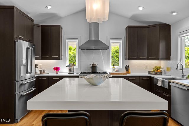 a kitchen with stainless steel appliances a stove refrigerator sink and cabinets