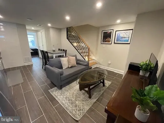 a living room with furniture flowerpot and wooden floor