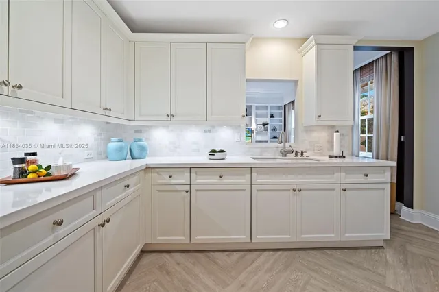 a kitchen with white cabinets and white appliances