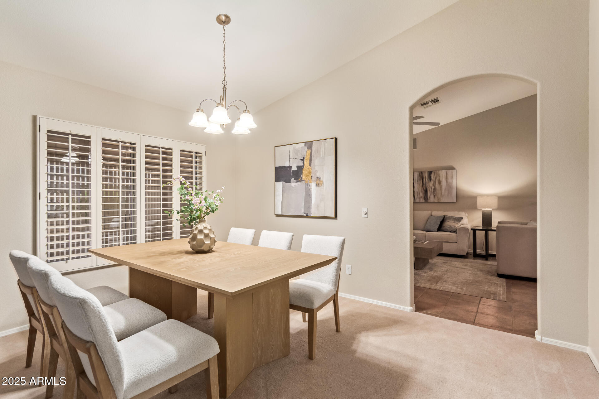 15596 West Flower Court Goodyear, AZ 85395 - Photo 13 of 35 a dining room with wooden floor a chandelier a wooden table and chairs