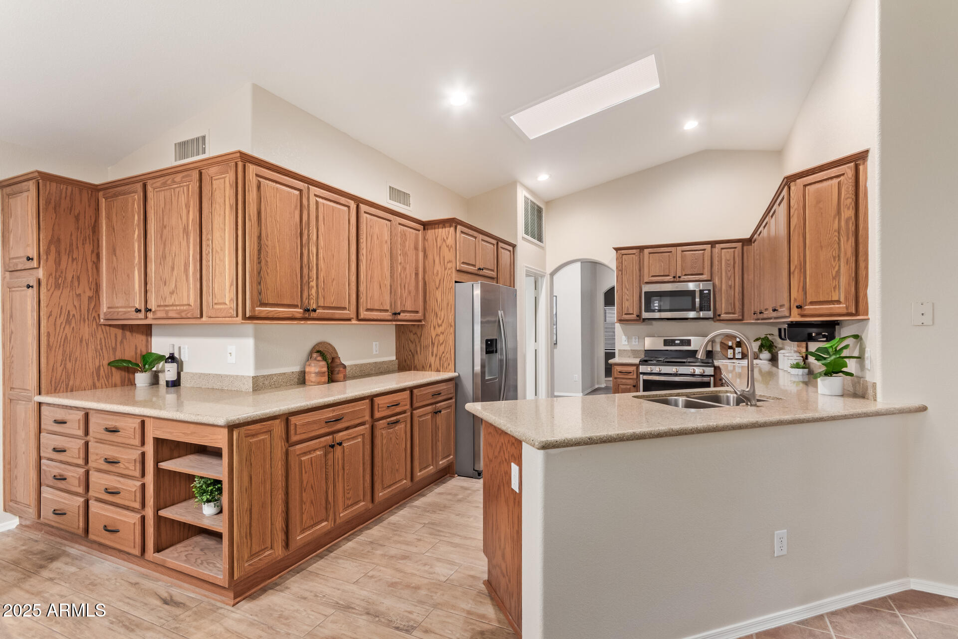 15596 West Flower Court Goodyear, AZ 85395 - Photo 17 of 35 a kitchen with stainless steel appliances a sink a stove a refrigerator cabinets and a window