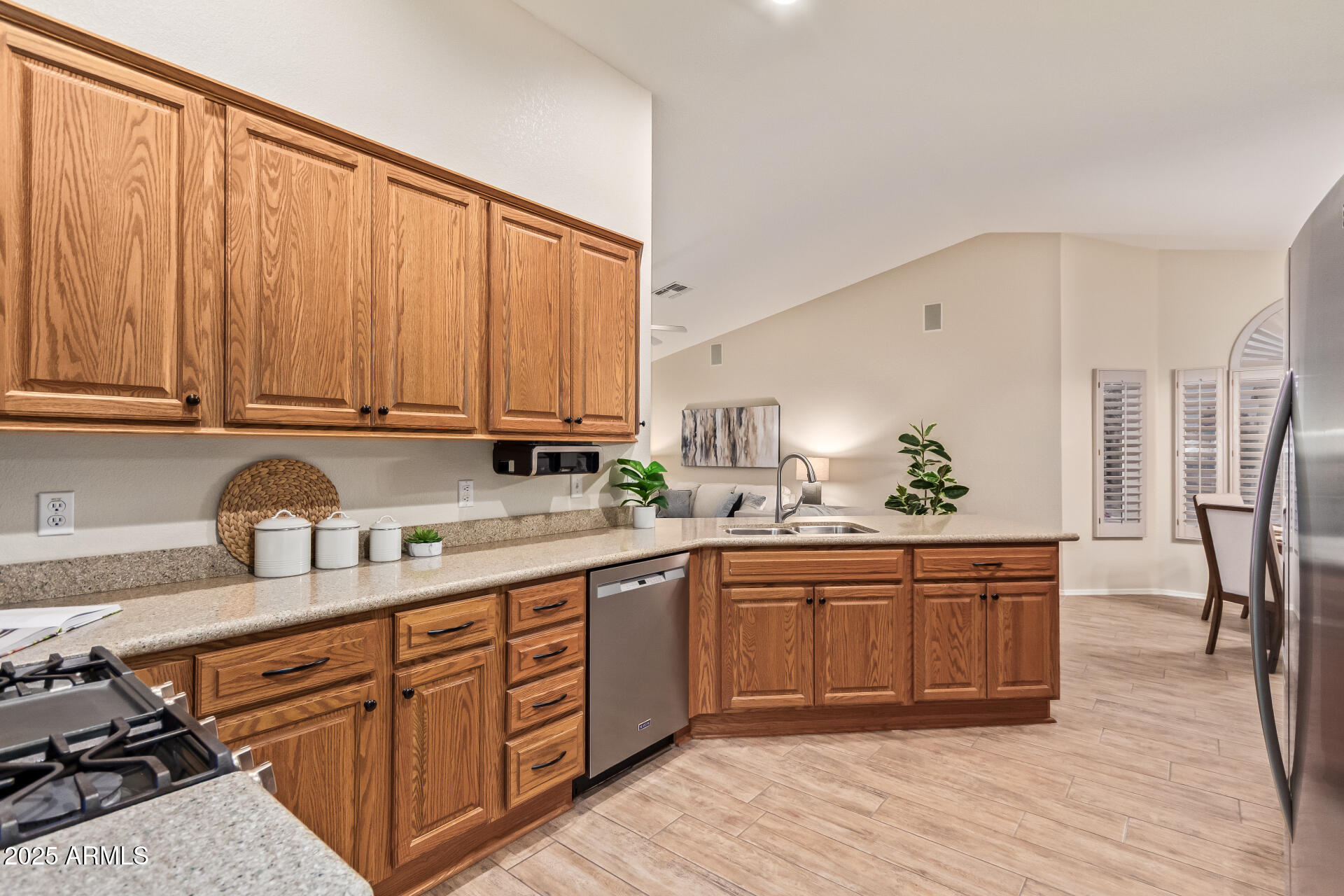 15596 West Flower Court Goodyear, AZ 85395 - Photo 19 of 35 a kitchen with stainless steel appliances granite countertop a table chairs sink and cabinets