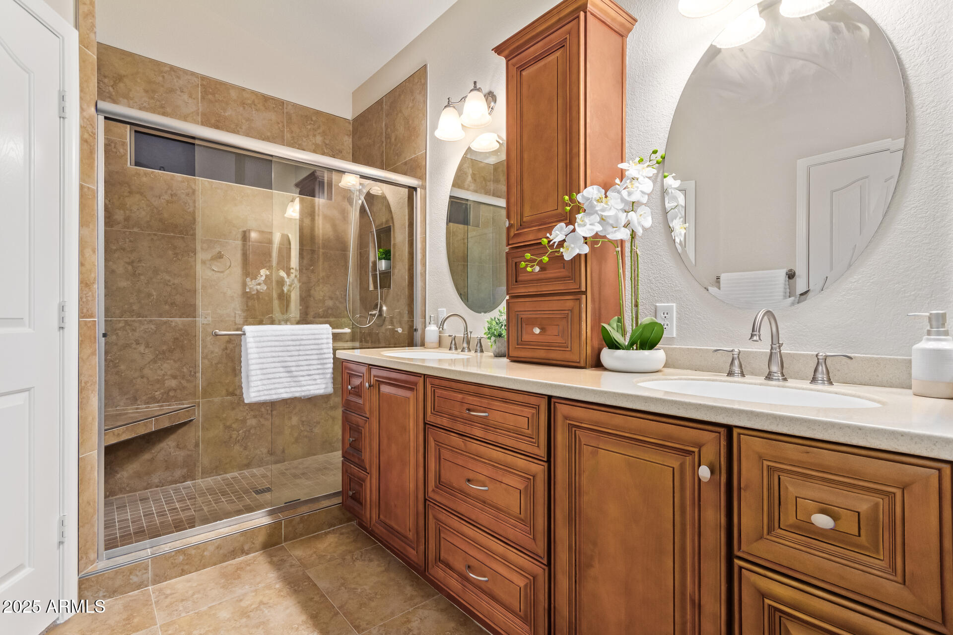 15596 West Flower Court Goodyear, AZ 85395 - Photo 23 of 35 a bathroom with a granite countertop sink a mirror and a shower