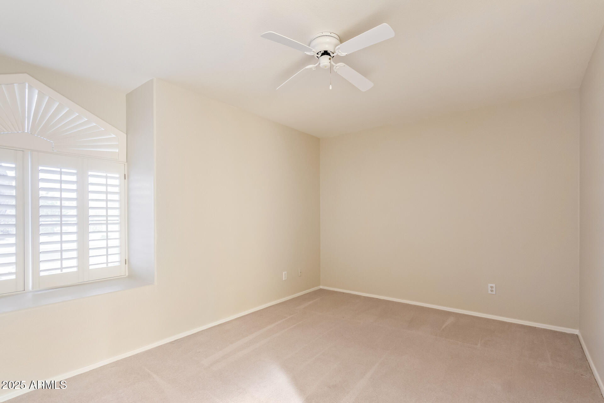 15596 West Flower Court Goodyear, AZ 85395 - Photo 27 of 35 an empty room with a window and a fan