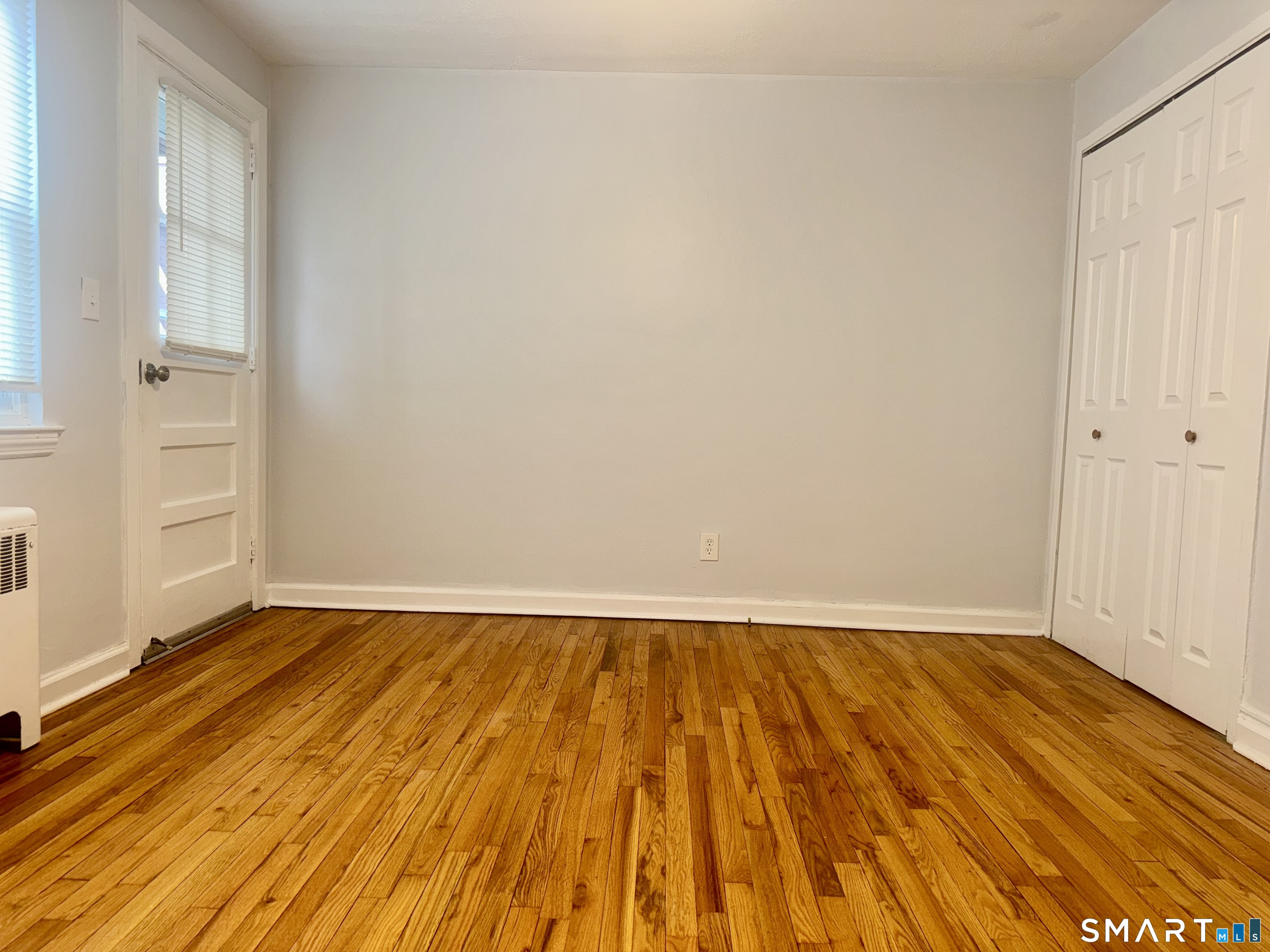 246 Seaton Road, Unit 2 Stamford, CT 06902 - Photo 11 of 18 a view of an empty room with wooden floor and a window