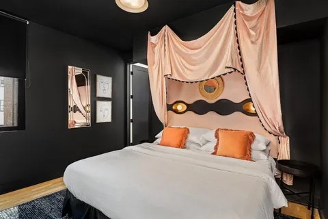 a bedroom with a bed and dresser next to a window