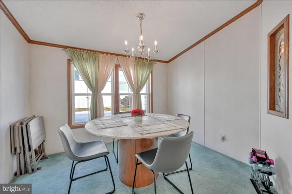 a view of a dining room with furniture and chandelier
