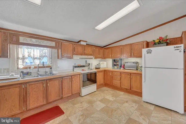 a kitchen with granite countertop a sink stove and cabinets