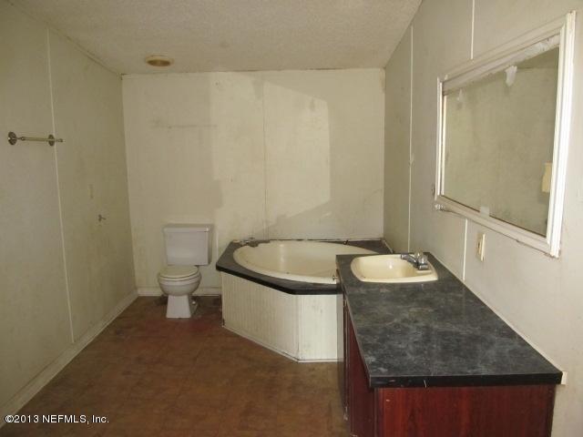 6359 Memory Lane Jacksonville, FL 32234 - Photo 7 of 11 a bathroom with a granite countertop sink and mirror with bathtub