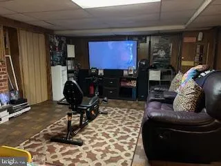 a living room with furniture a flat screen tv and a window