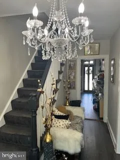 a view of a dining room with wooden floor and chandelier