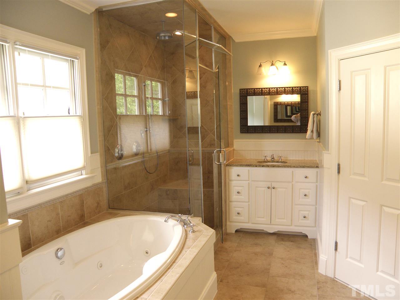 2702 Bedford Avenue Raleigh, NC 27607 - Photo 18 of 25 a bathroom with a granite countertop tub sink a mirror and a shower